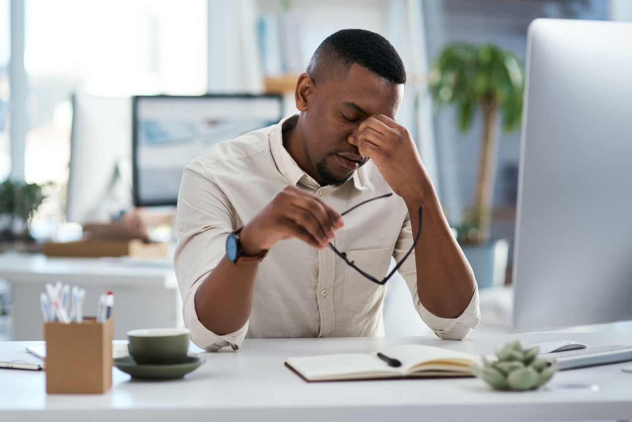 Shot of a young businessman looking stressed out while working in an office