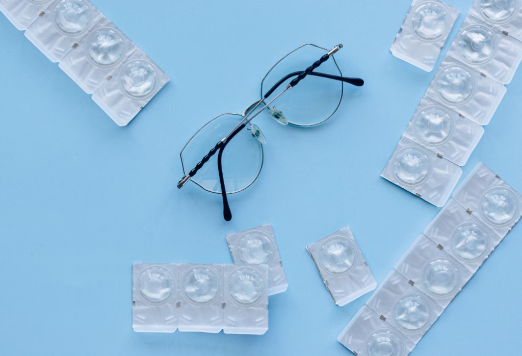 eye glasses and contact lenses on a blue surface